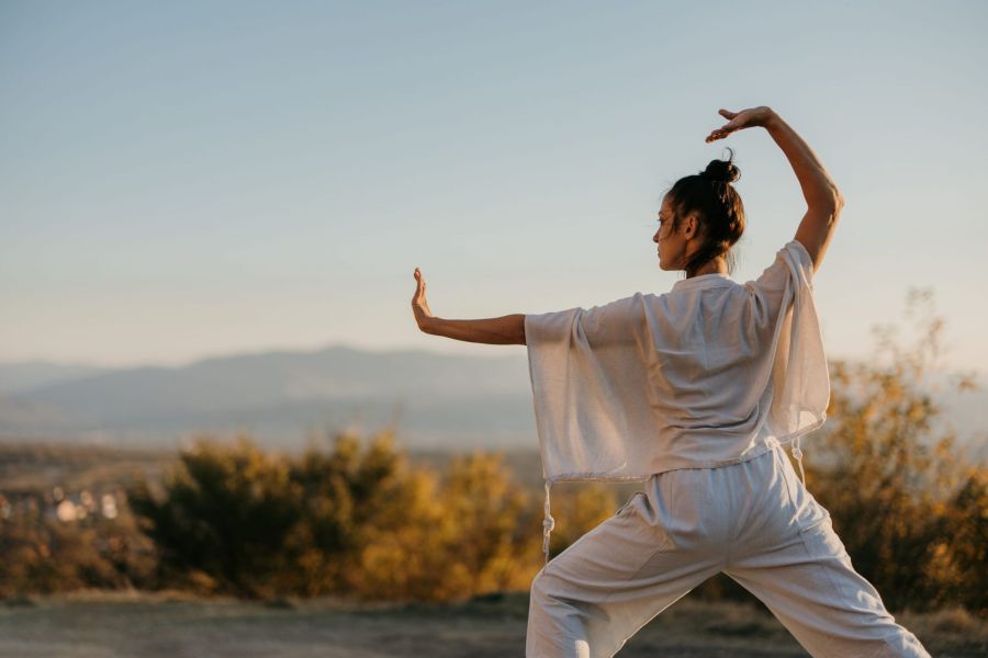 Frau praktiziert Qi Gong zur Stärkung von Körper und Geist im Rahmen des Yang Sheng Coachings